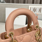 Dior mini handbag light pink quilted leather with rounded top handle and gold hardware close-up