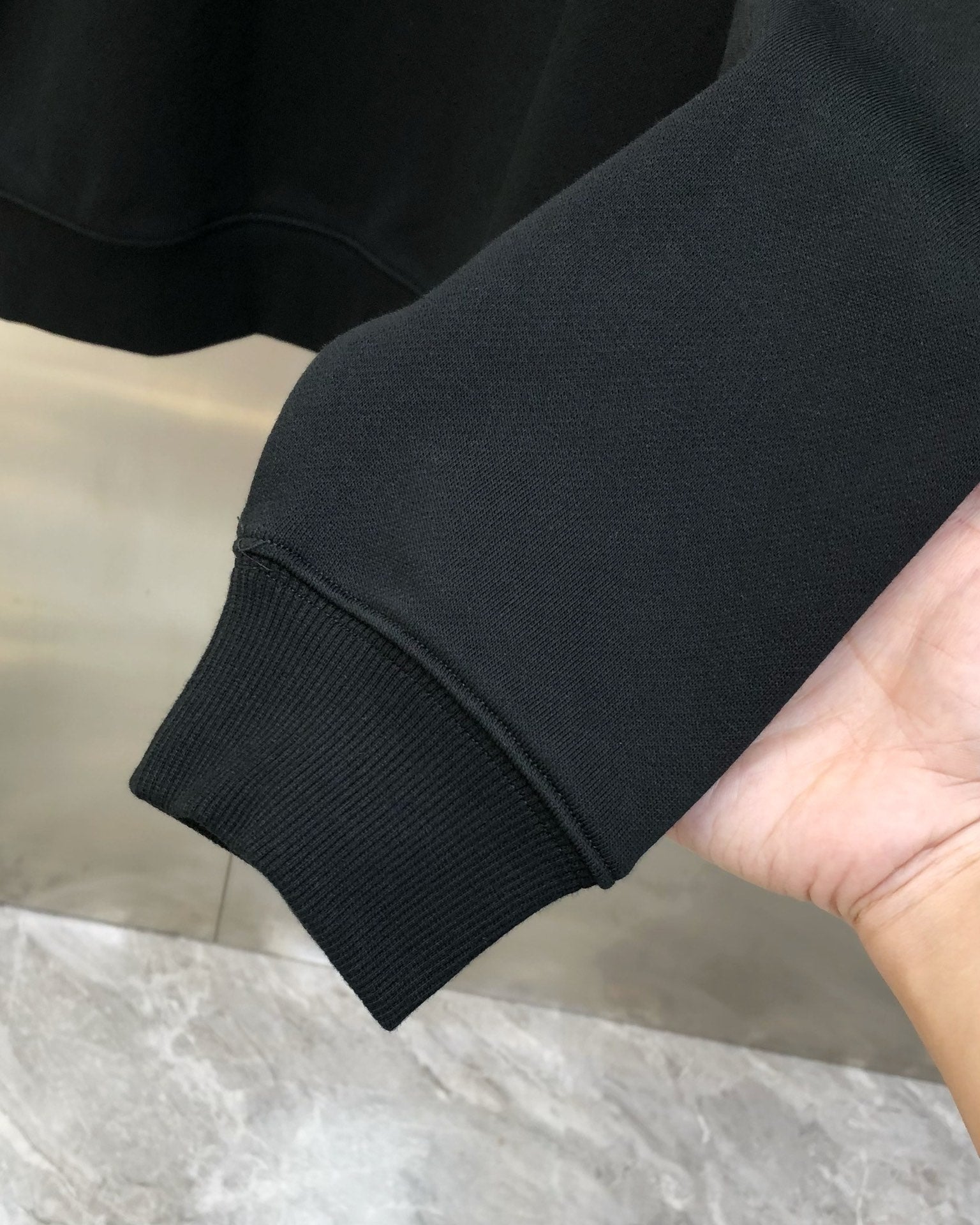 Black crewneck sweatshirt sleeve cuff with ribbed knit hem