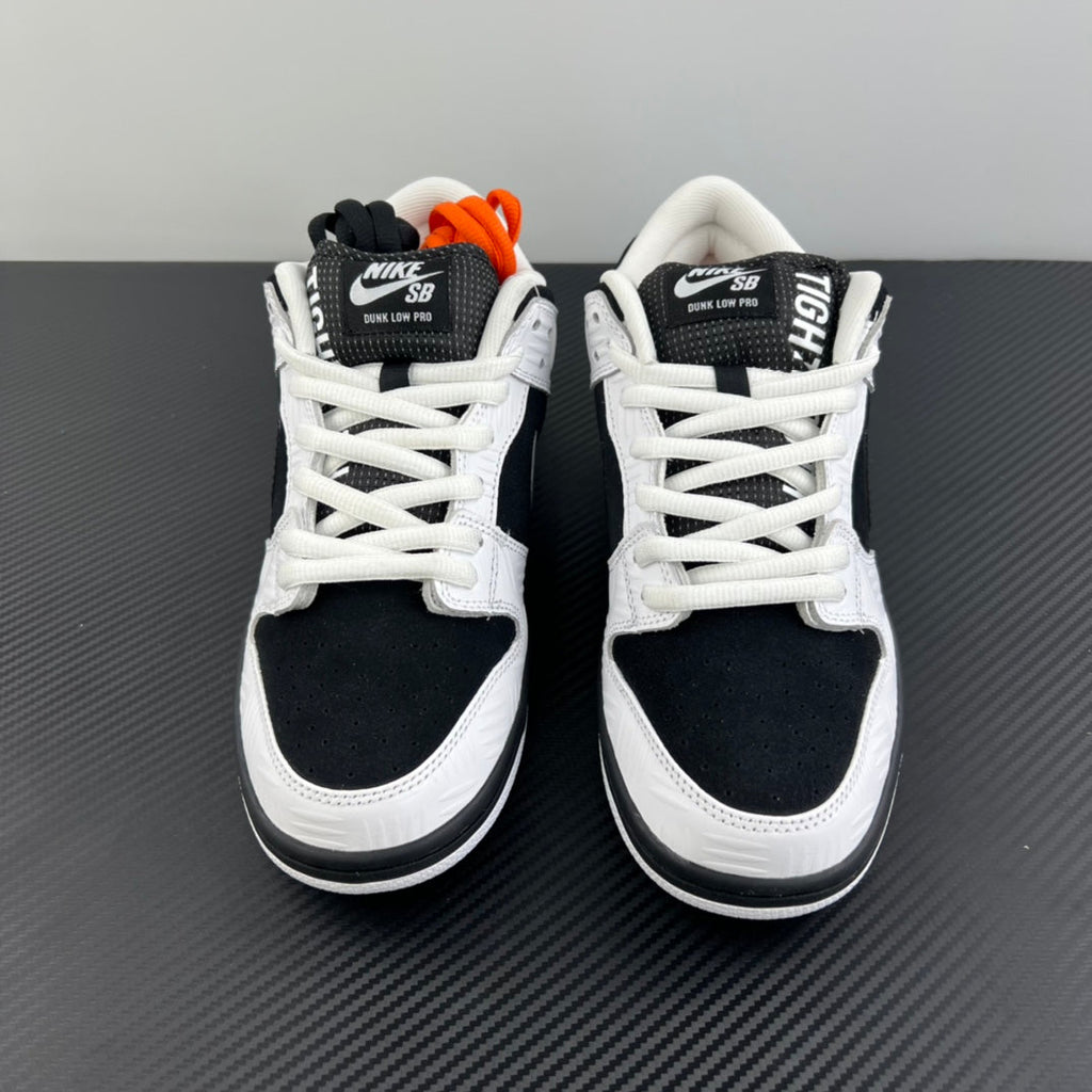 Pair of black and white low-top sneakers with white laces and black heel panels
