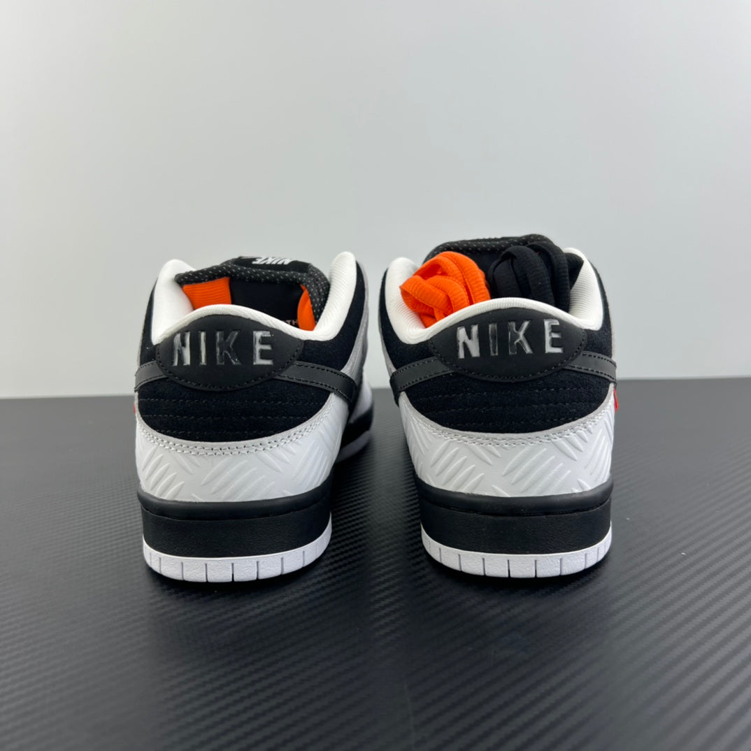 Black and white sneakers with white midsole and orange accents at the heel collar