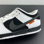 Close-up side view of black and white low-top sneaker with swoosh and orange patch