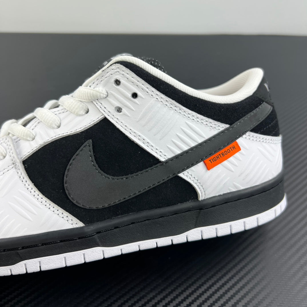Close-up side view of black and white low-top sneaker with swoosh and orange patch