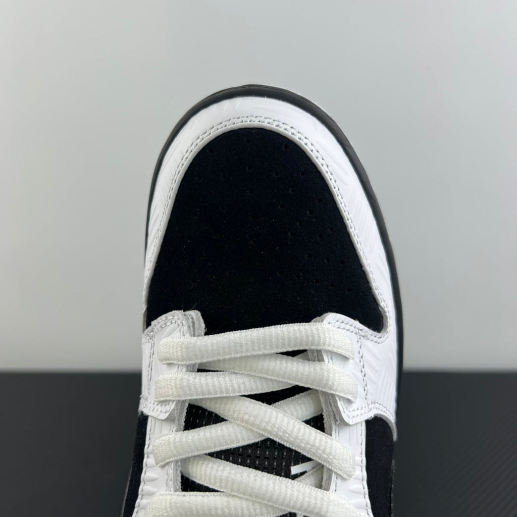 Close-up of black and white sneaker toe and lace-up front with textured panels