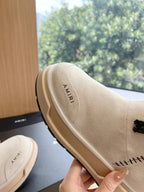 Amiri light beige suede boots, close-up of heel and side logo with faux fur collar