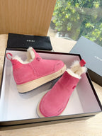 Pair of pink suede Chelsea boots with faux shearling lining and red tabs