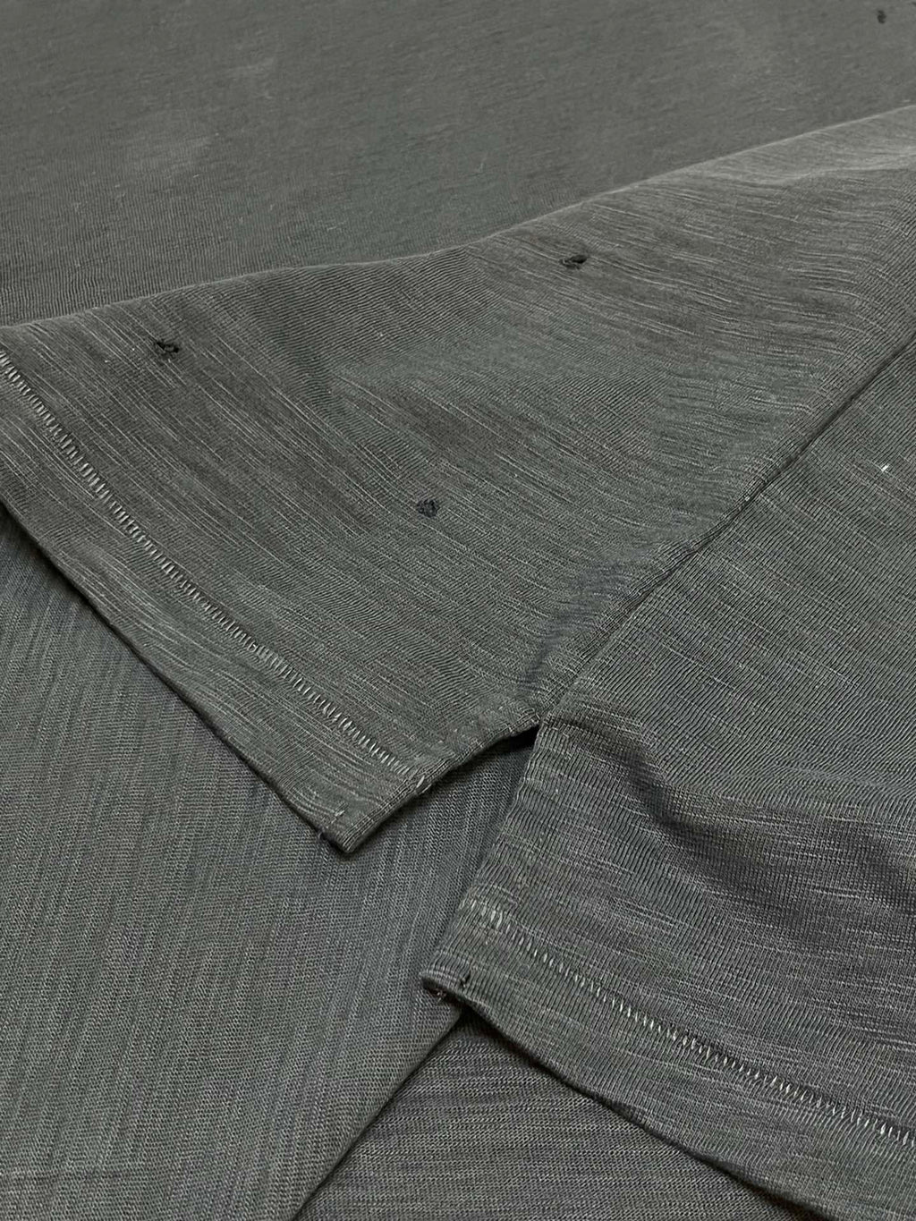 Dark T-shirt sleeve and hem seam with textured fabric detail