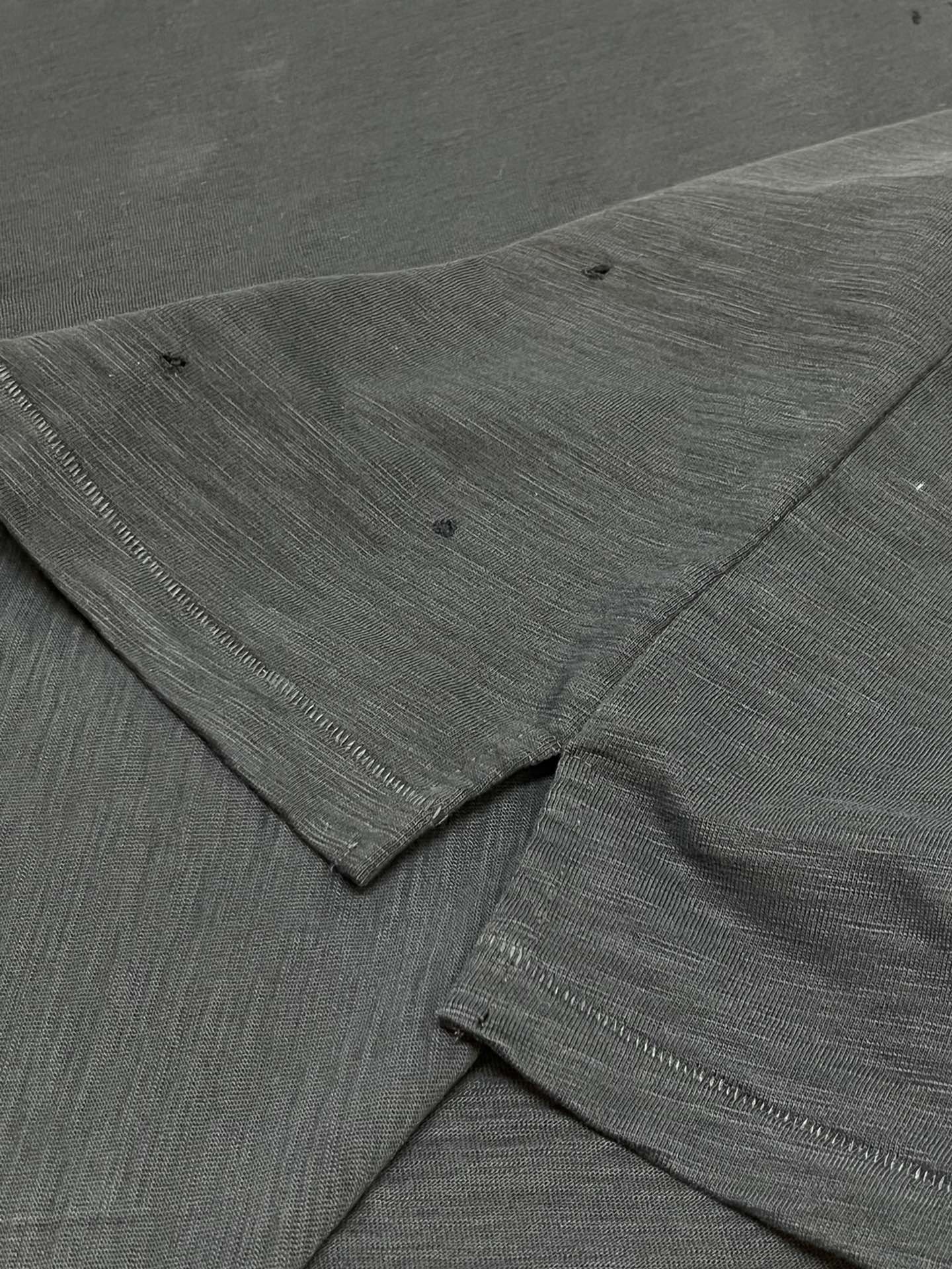 Dark T-shirt sleeve and hem seam with textured fabric detail