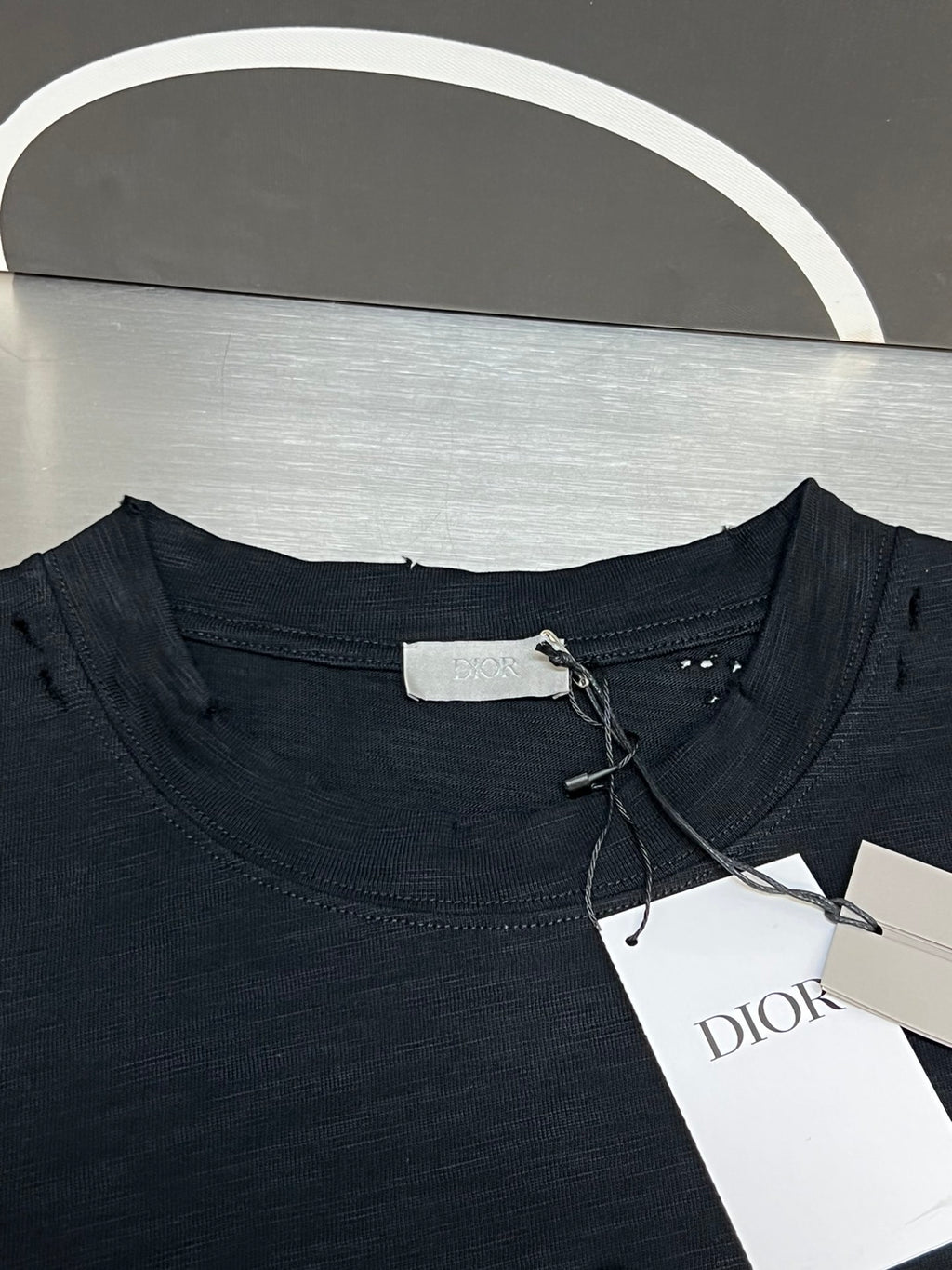 Christian Dior T-shirt neckline detail with size tag and hanging white label