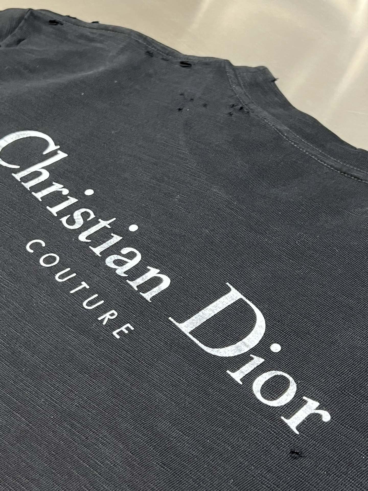 Christian Dior Couture logo graphic on dark T-shirt fabric