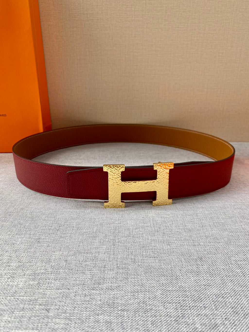 Red leather belt with tan underside and gold-tone H buckle
