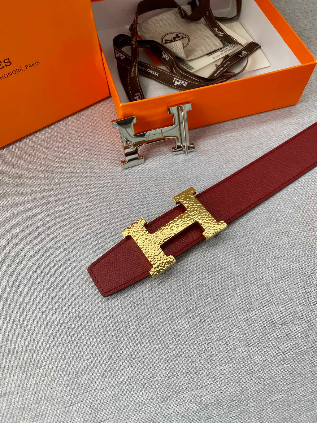 Red leather belt with gold-tone H buckle and red keeper strap