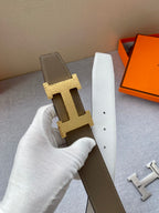 Brown and white leather belt with gold-tone H buckle and punched holes.