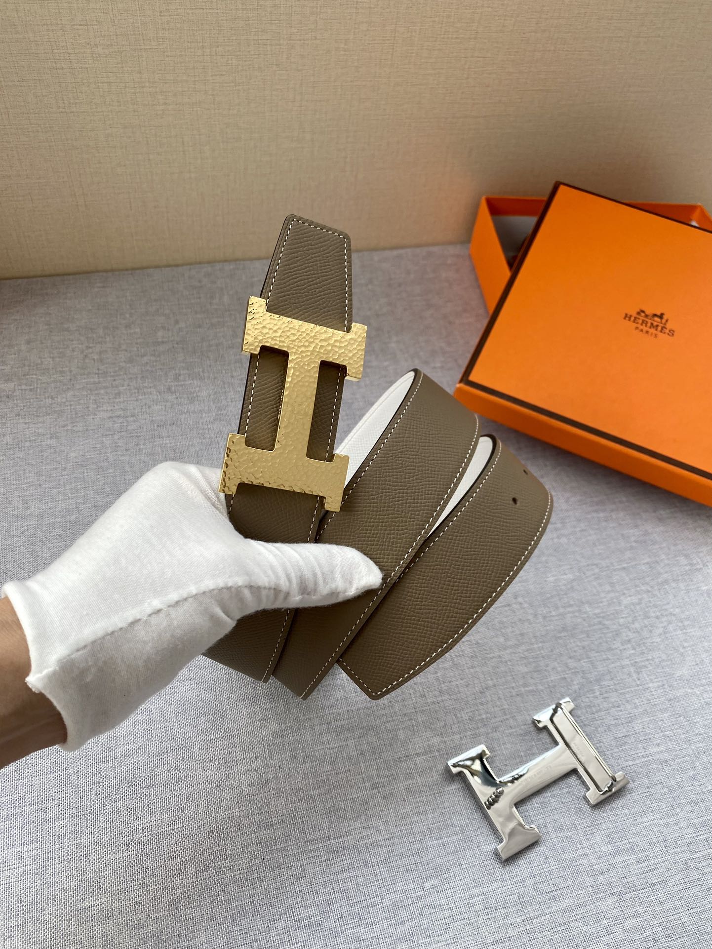 Brown leather belt with gold-tone H buckle; includes extra belt keepers.