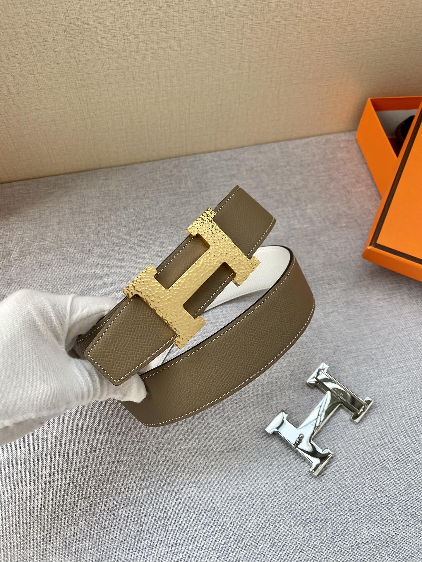 Brown leather belt with gold-tone H buckle and top-stitched keeper strap.