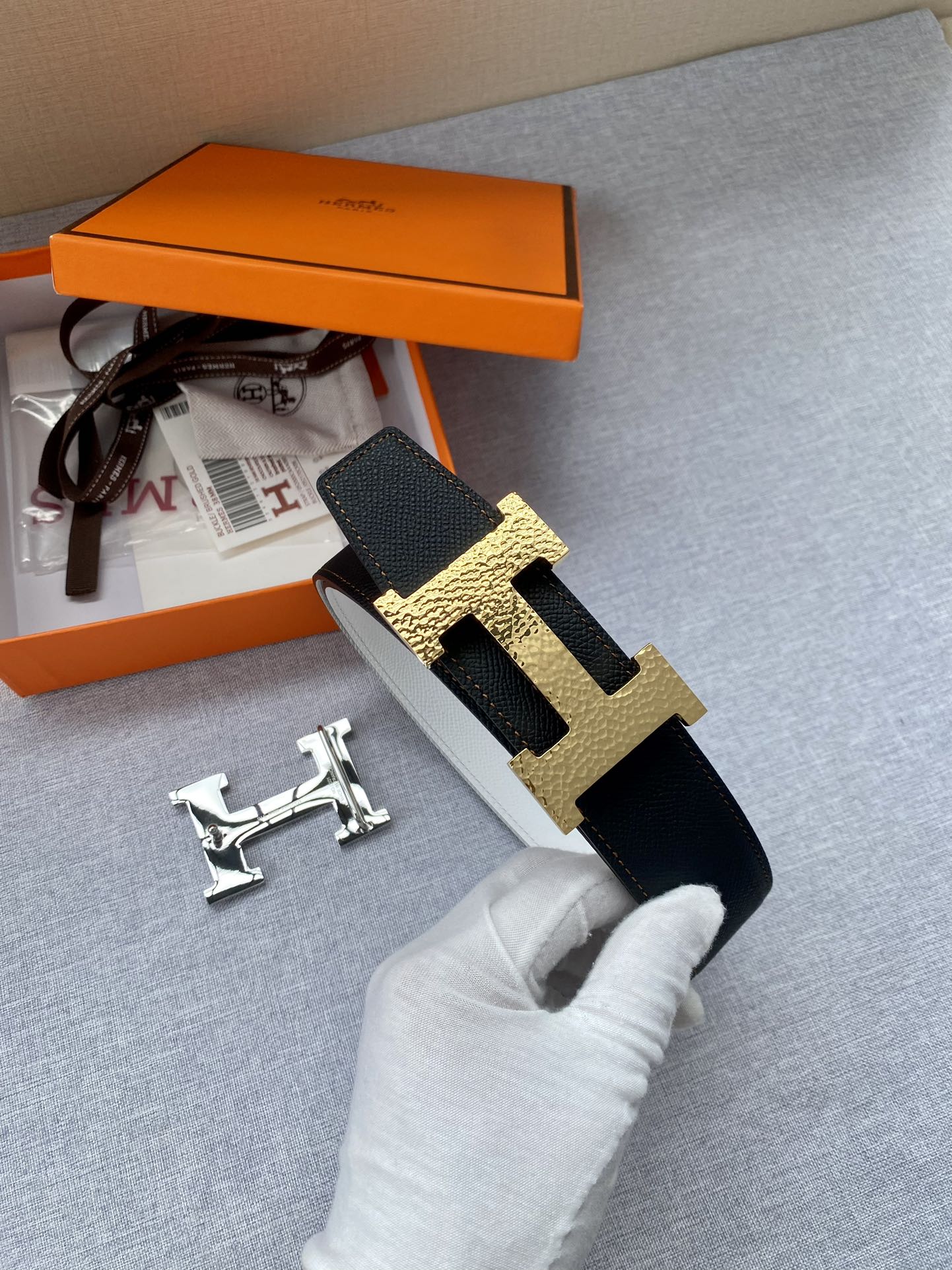 Black leather belt with gold-tone H buckle and included strap end hardware