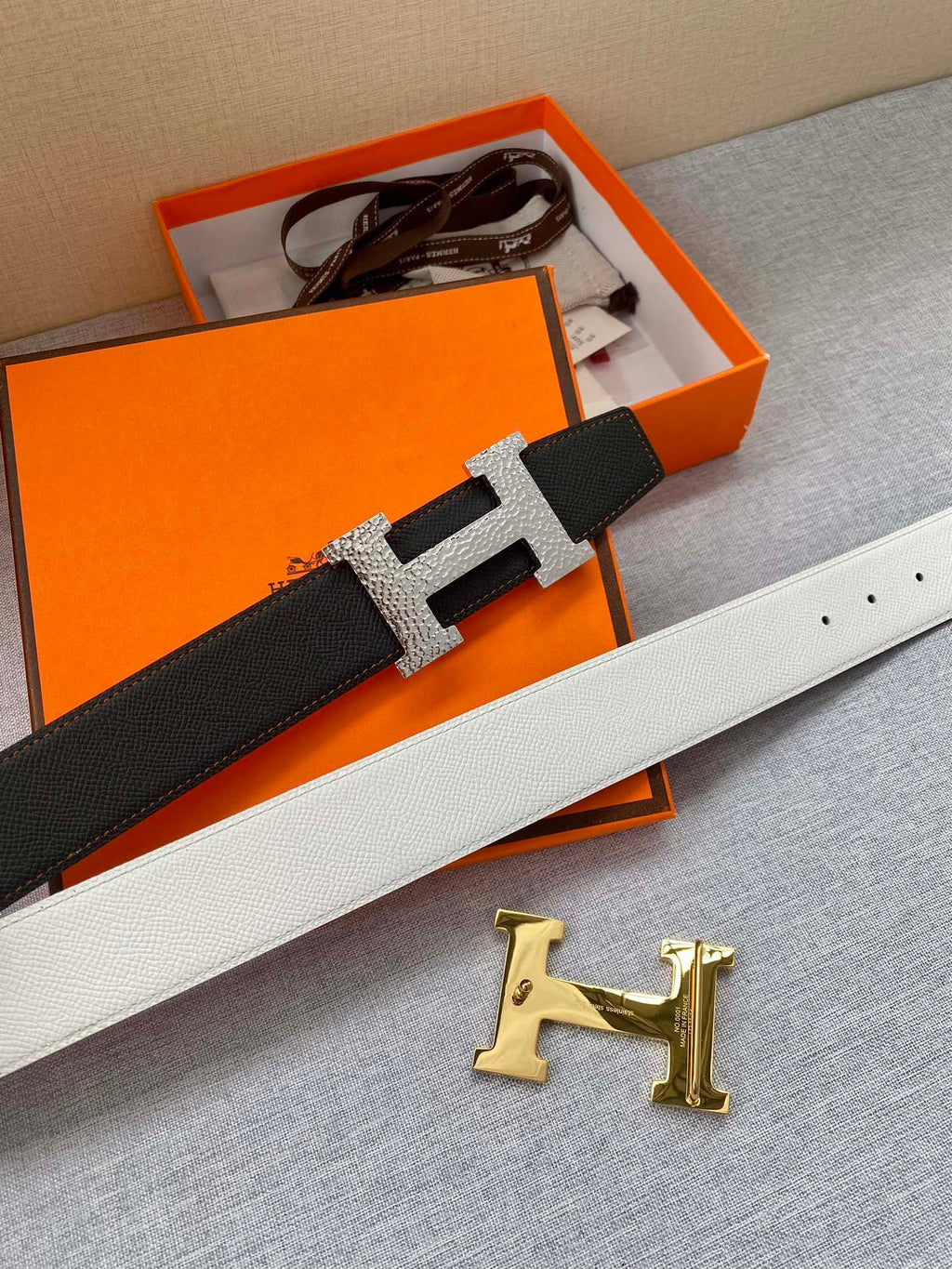 Black leather belt with silver-tone H buckle set on keeper strap