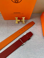 Orange leather belt strap with gold H logo buckle and punched holes