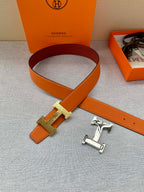 Orange leather belt with gold H buckle and silver-toned keeper