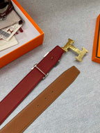 Brown and maroon belt with gold buckle; extra strap pieces shown