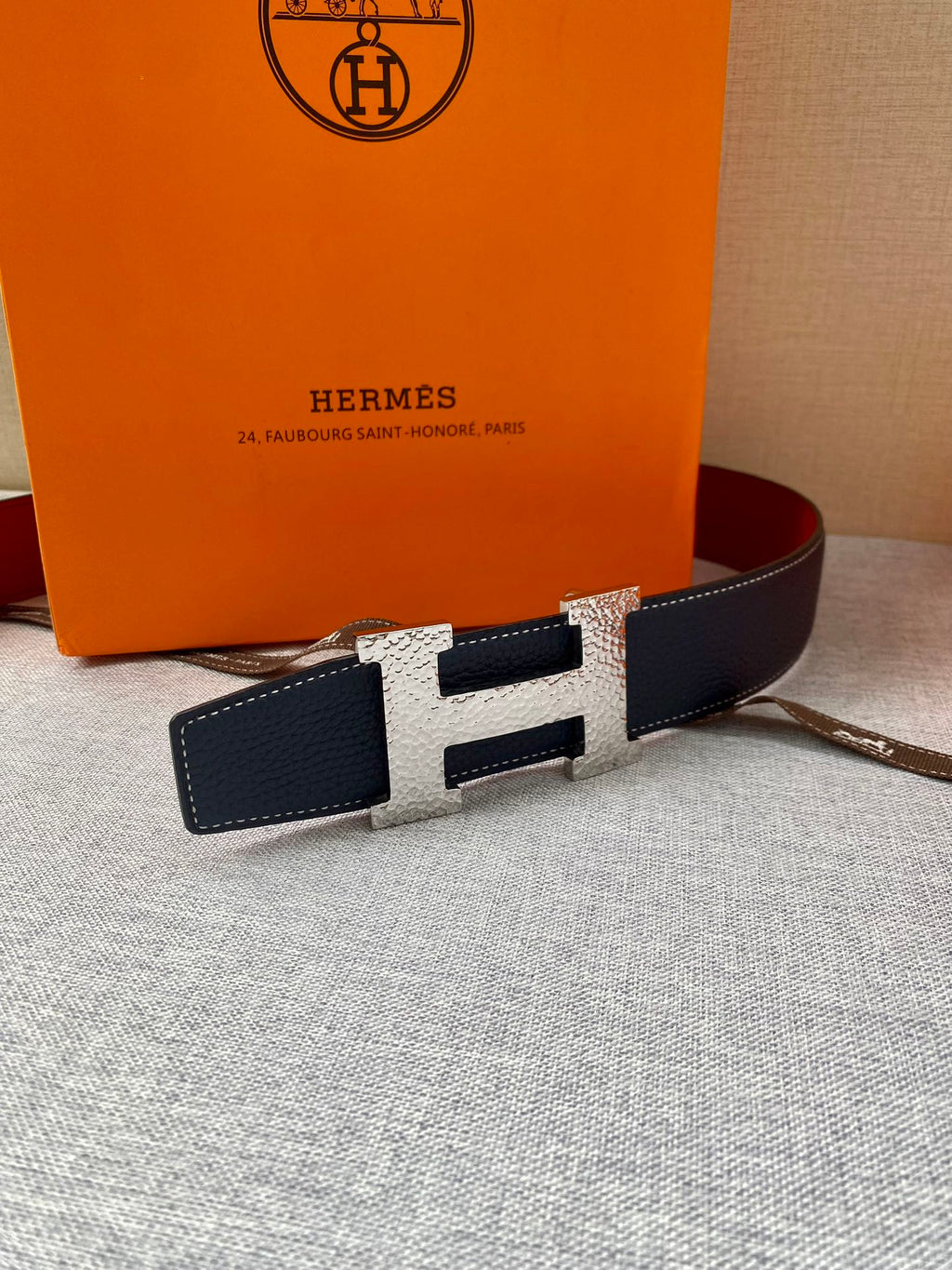 Navy leather belt with gold-tone H buckle and rectangular keeper panels