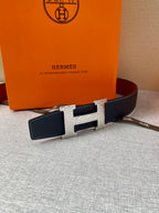 Navy leather belt with gold-tone H buckle and rectangular keeper panels