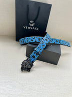 Designer belt with blue logo strap and ornate silver lion buckle, with gift box