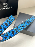 Belt strap close-up with blue repeating VERSACE lettering and black base