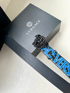 Designer belt on gray gift box, blue logo strap with ornate silver buckle