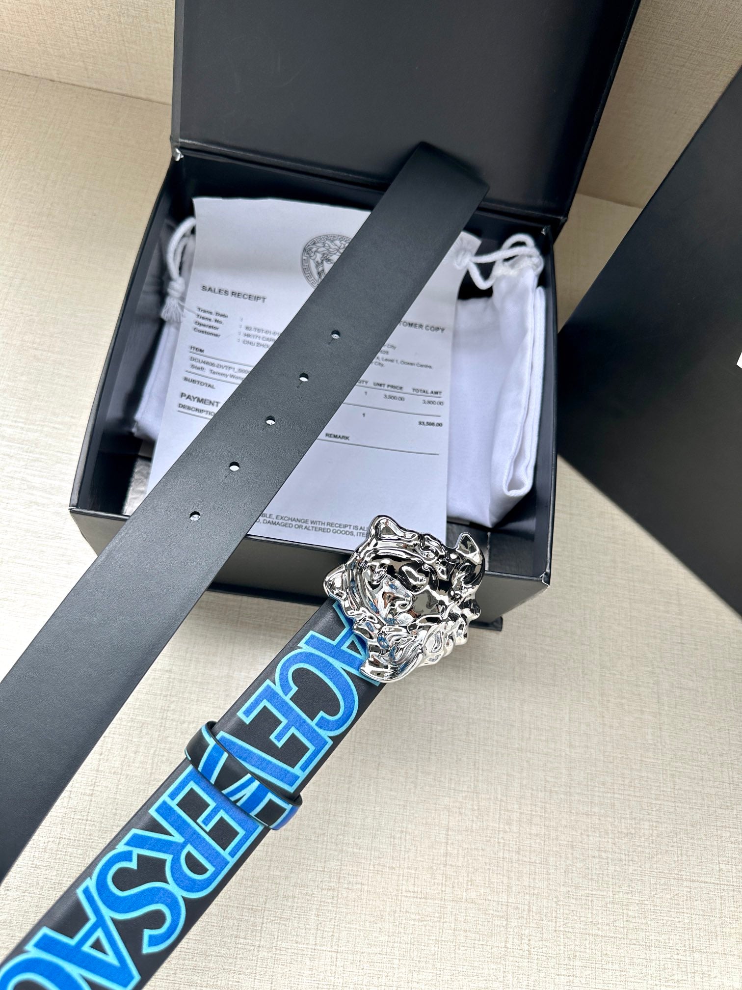 Versace belt in box packaging, dark strap with blue logo and silver Medusa buckle
