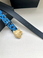 Versace belt close-up: dark blue strap with holes and gold Medusa buckle.