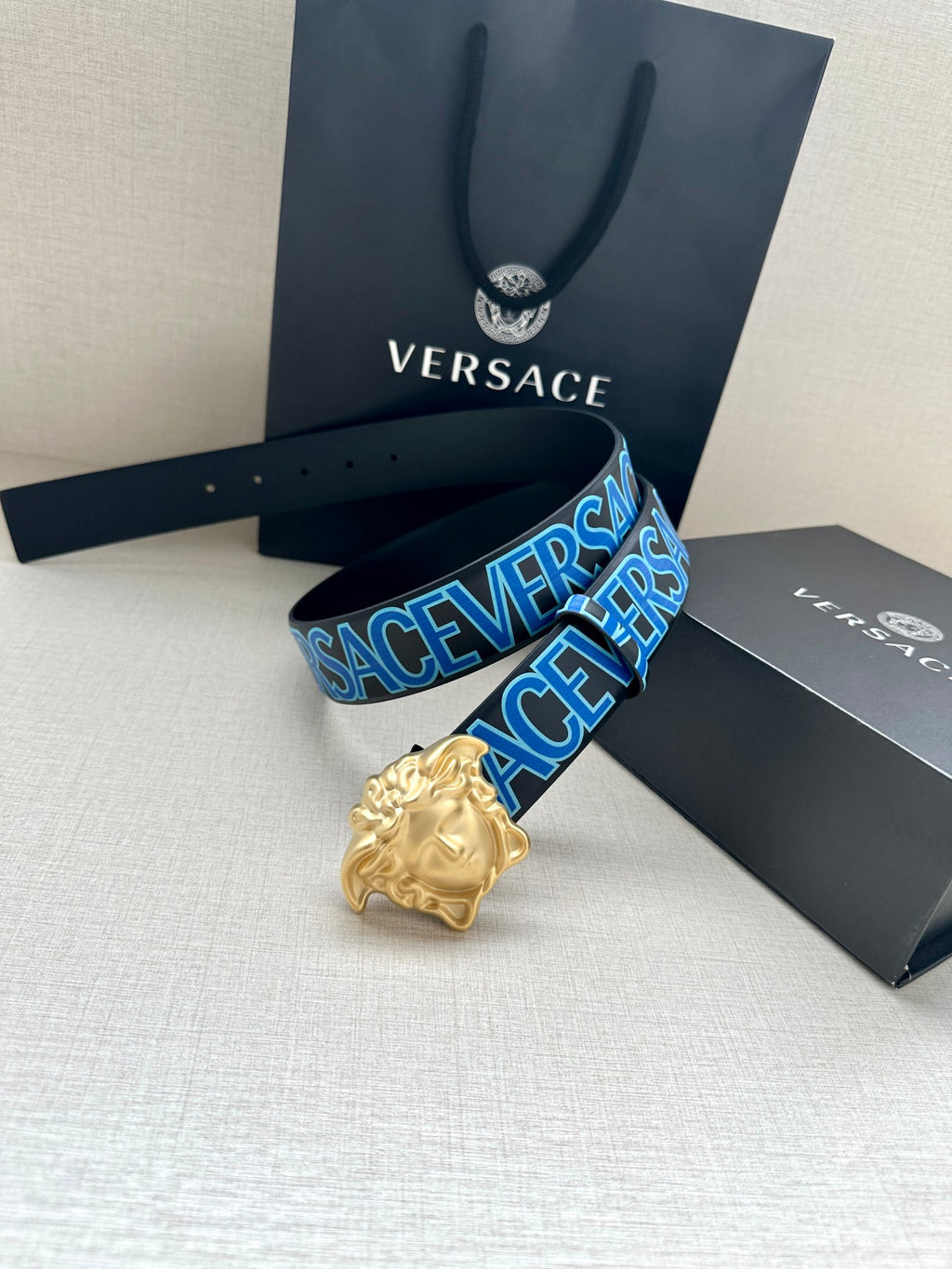Versace belt, dark blue strap with Versace logo print and gold Medusa buckle.