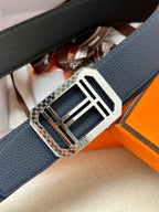 Navy leather belt close-up with silver square buckle and embossed trim