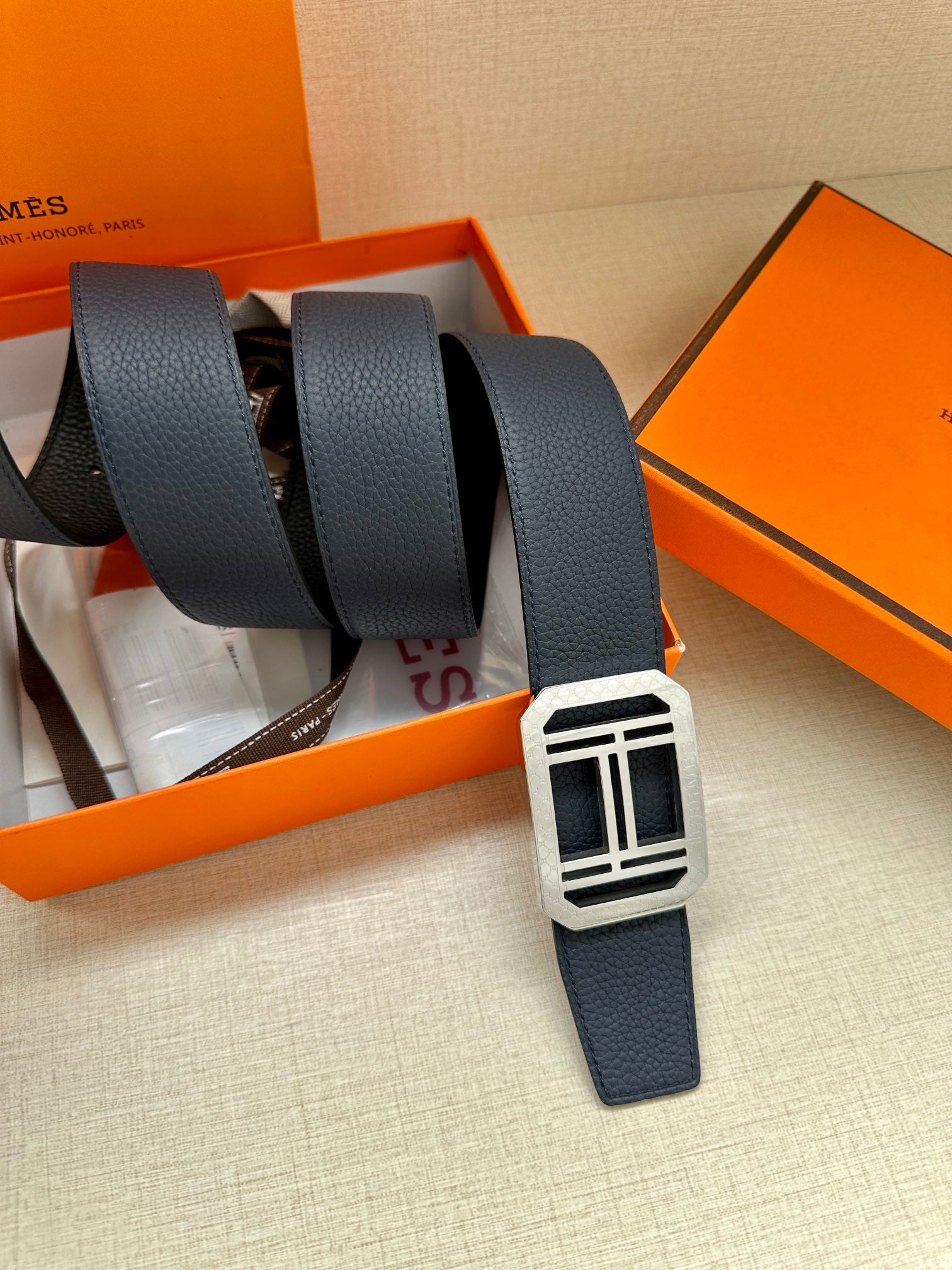 Navy leather belt with multiple straps and silver square buckle