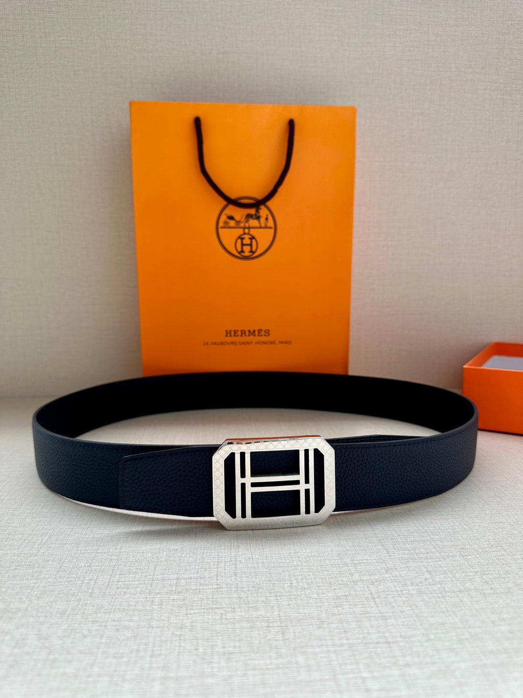 Navy leather belt with silver square buckle, laid flat for viewing