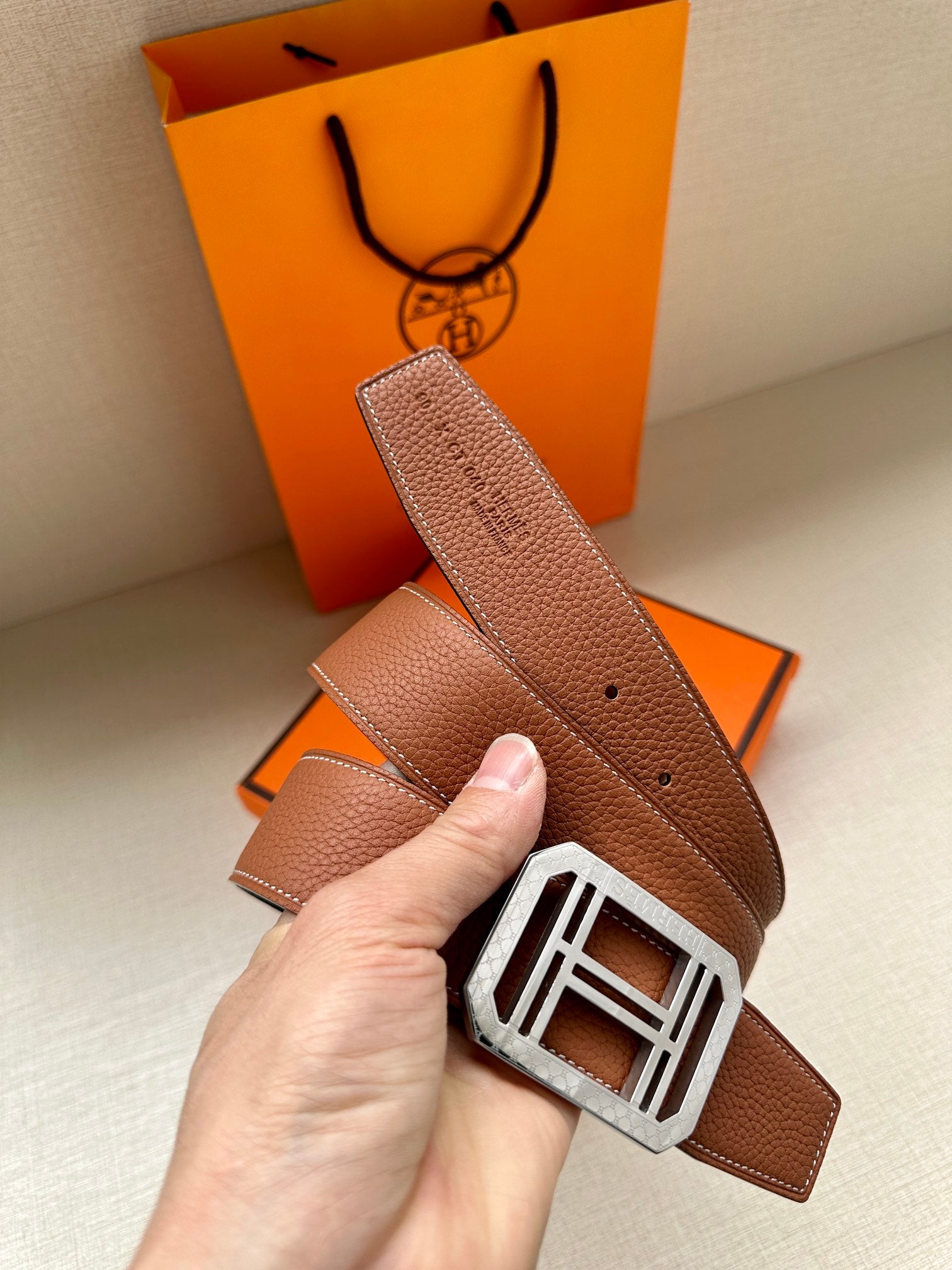 Brown leather belt with silver-toned square H buckle and perforated adjustment holes