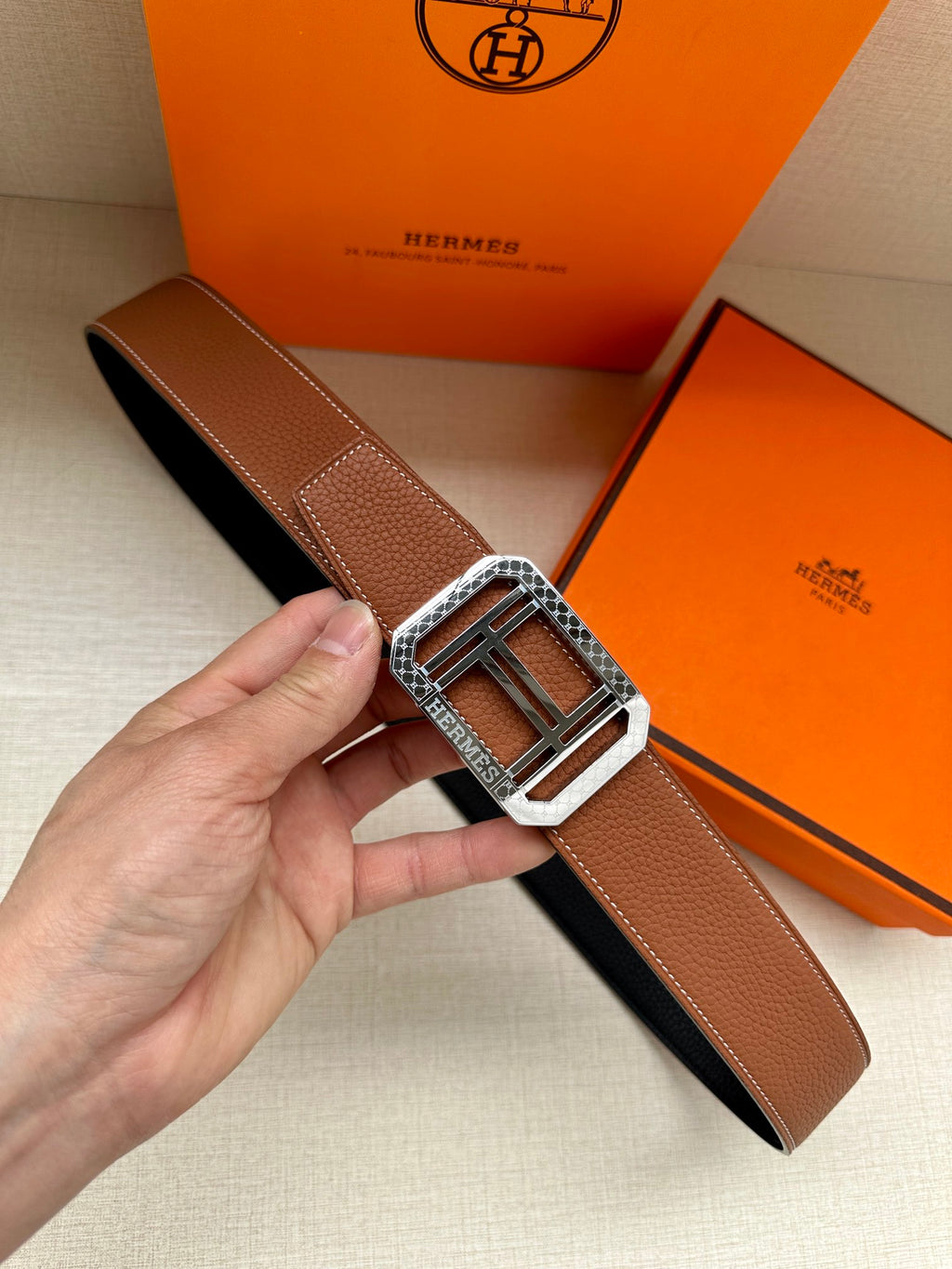 Brown leather belt with silver-toned square H buckle and keeper tab