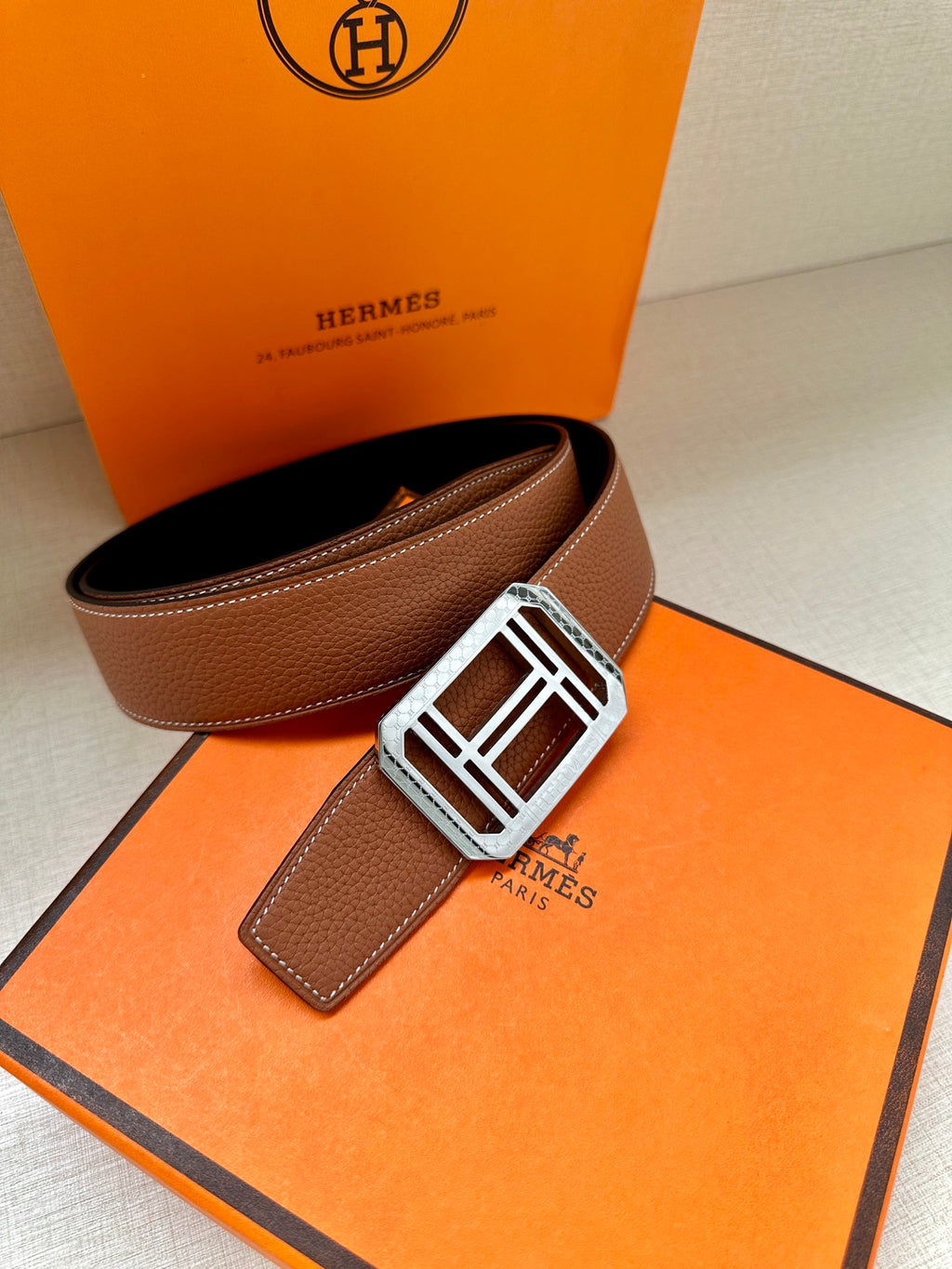 Brown leather belt with silver-toned H buckle and adjustable strap end