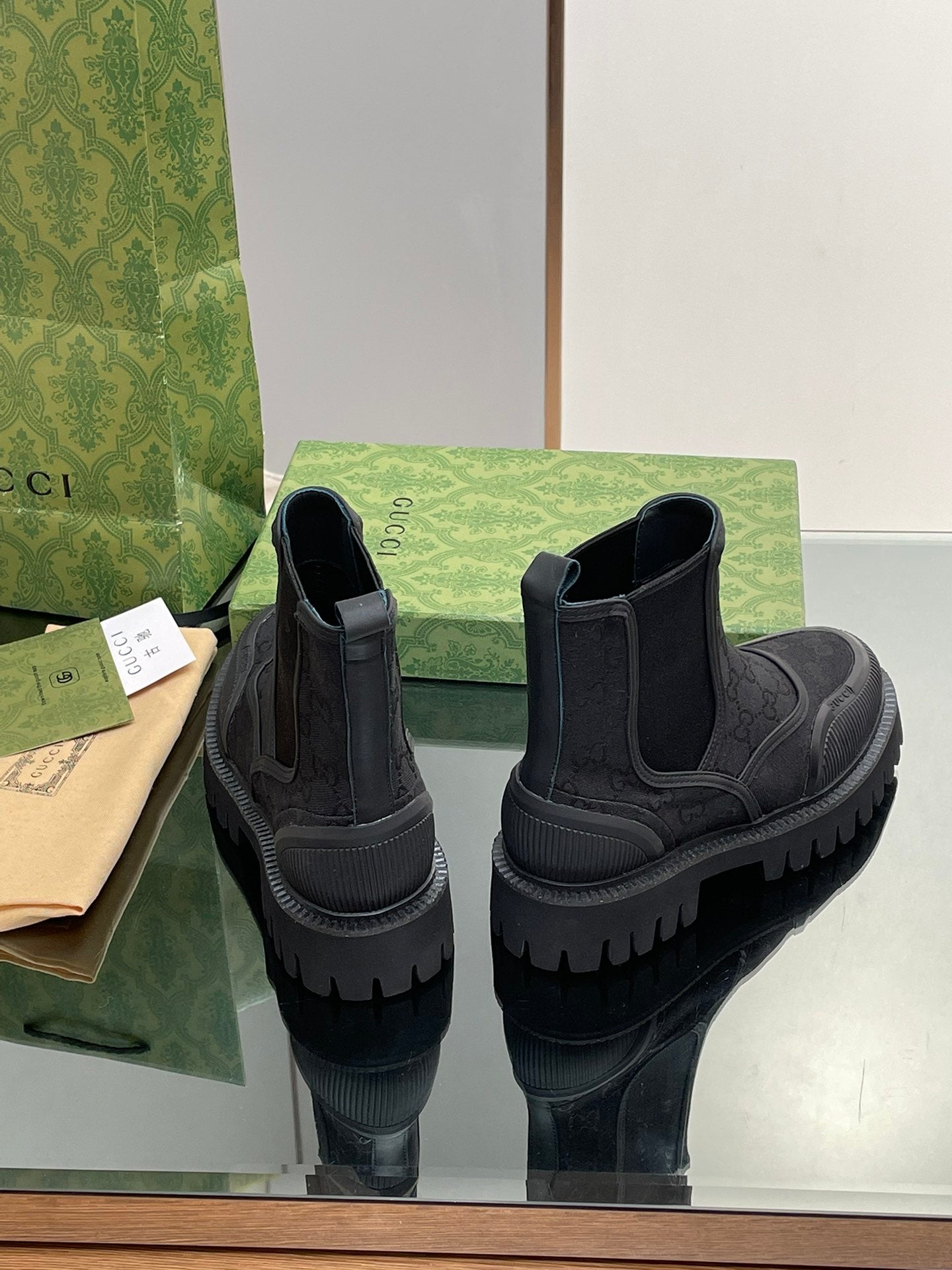 Gucci unisex Chelsea boots pair, elastic side panels, embossed logo pattern, tread sole