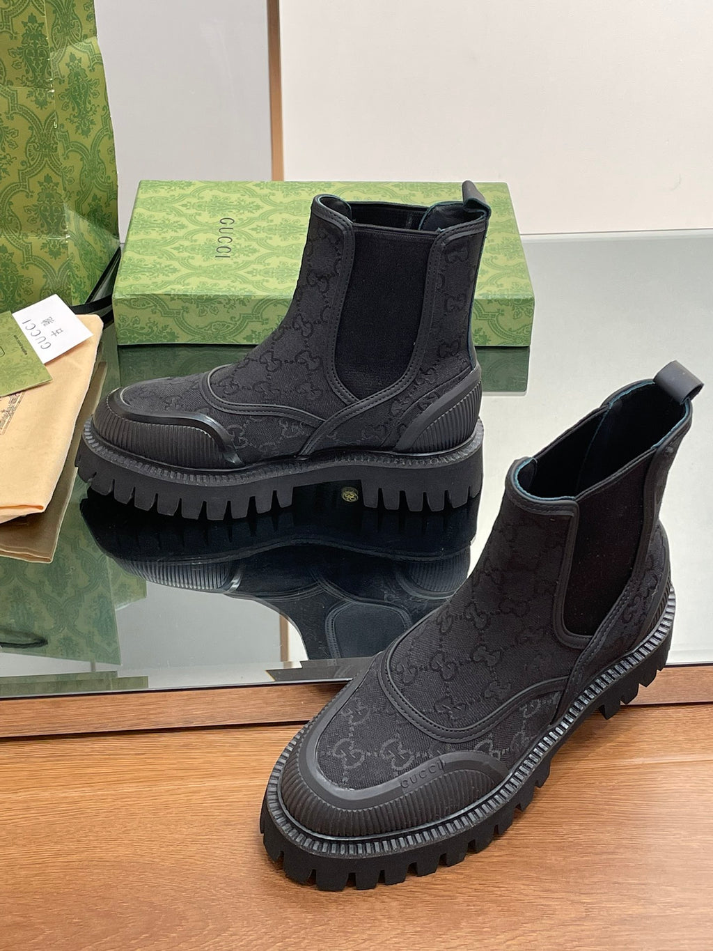 Gucci unisex Chelsea boots, dark upper with embossed monogram, platform lug sole, gore