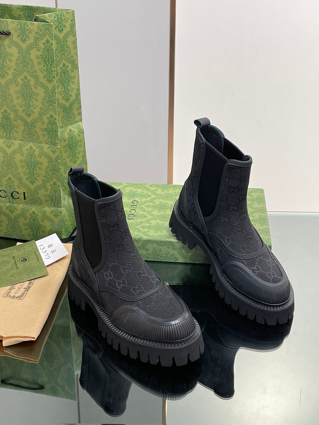 Gucci unisex Chelsea boots, dark embossed pattern, elastic side panels, chunky sole