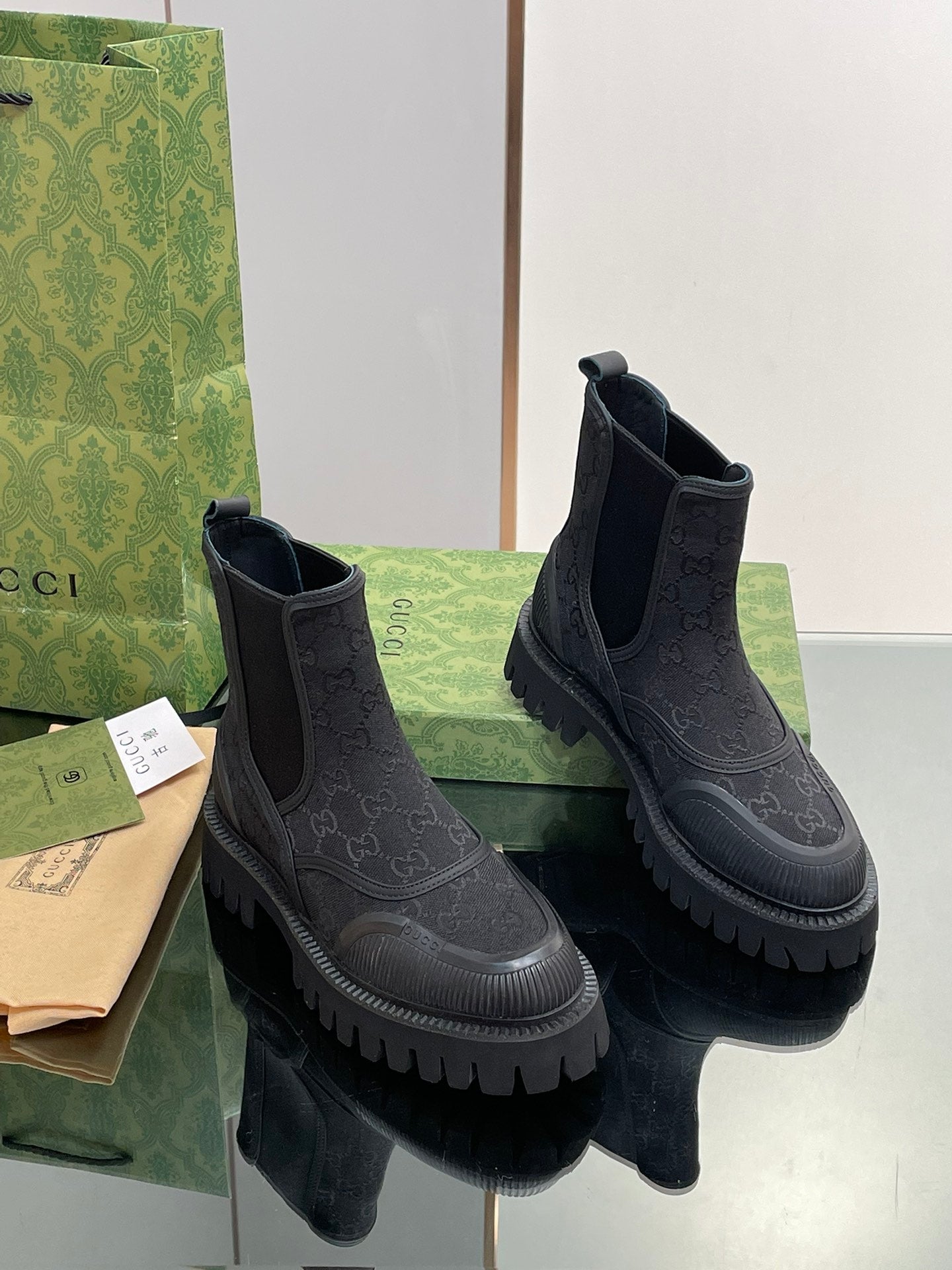 Gucci unisex Chelsea boots, dark embossed pattern, elastic side panels, chunky sole