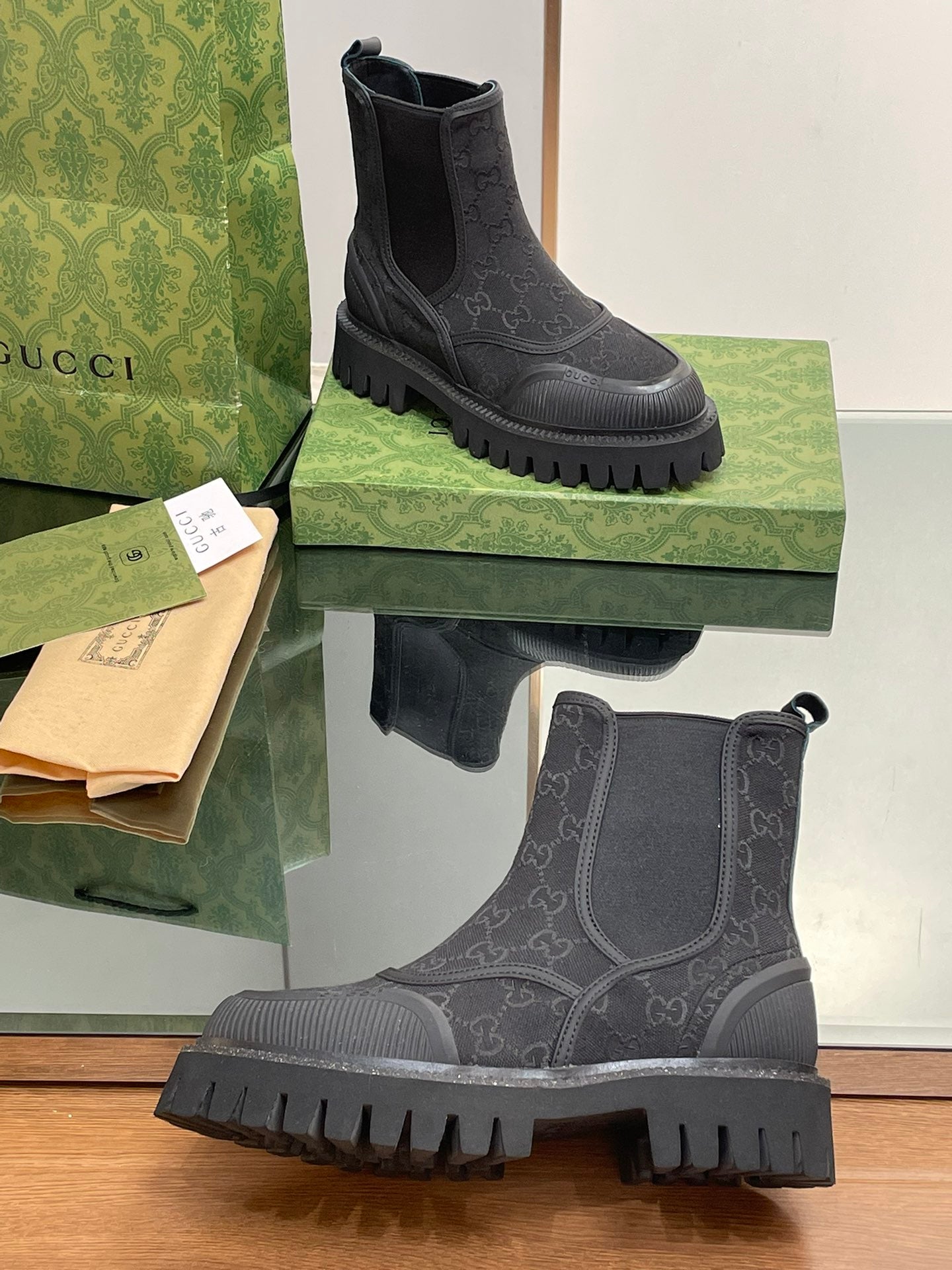 Gucci unisex Chelsea boots pair, dark gray upper with embossed monogram, tread sole
