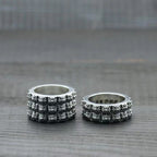 Silver chrome style rings with repeating floral motifs, two-ring side view