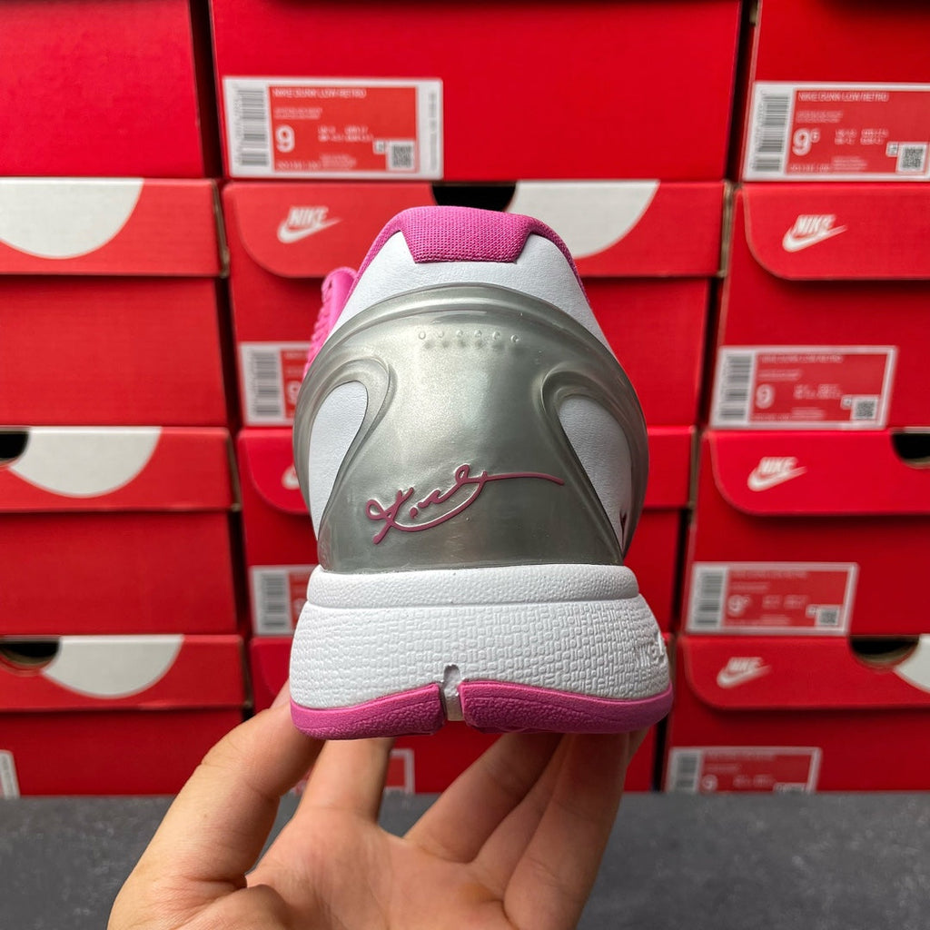 Pink basketball shoe heel with lace-up opening and gray rear sole, back view.