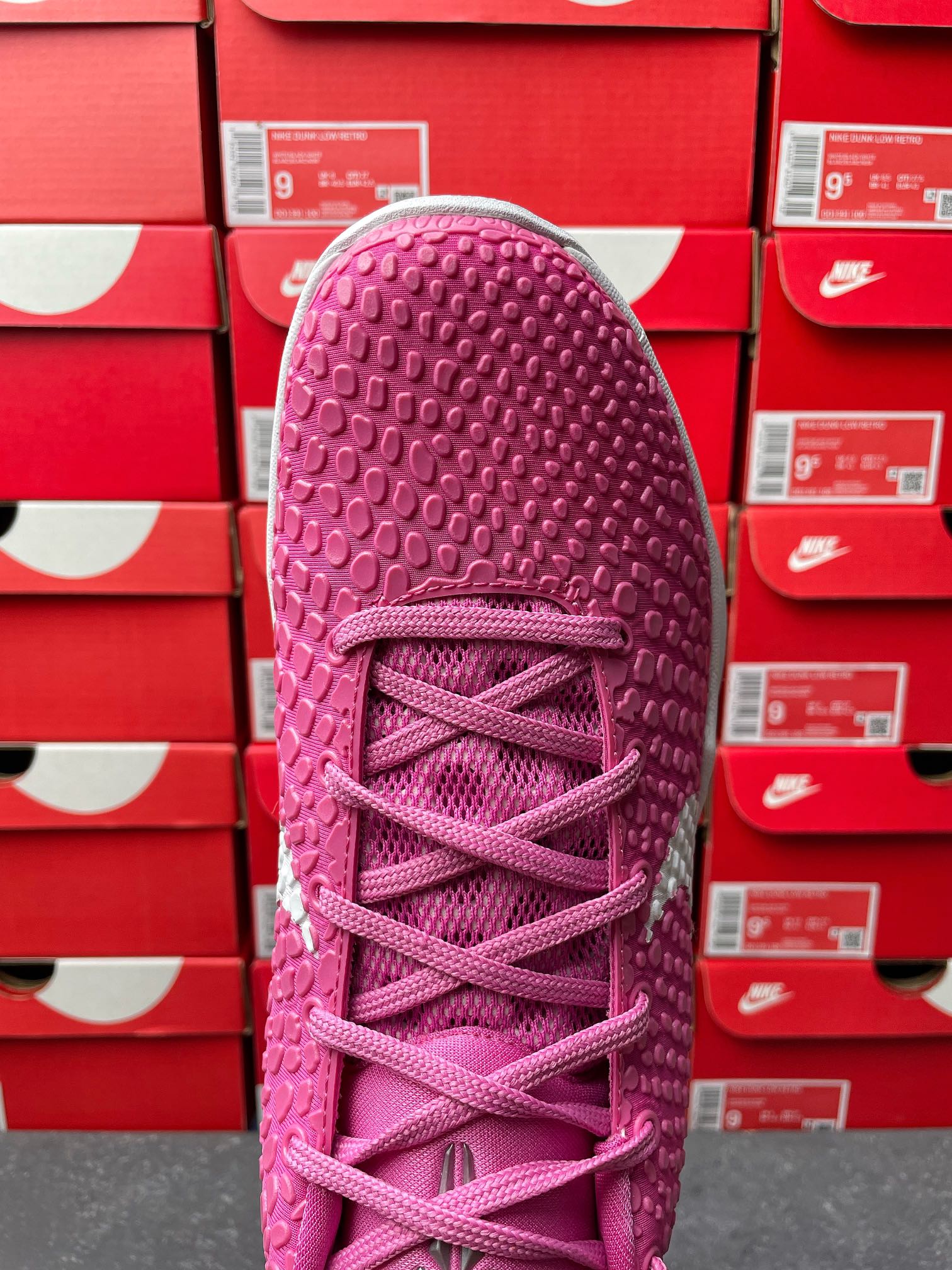 Pink basketball shoe heel and laces with textured upper, angled rear view.