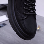 Black leather sneakers close-up with lace eyelets, textured panels, thick sole