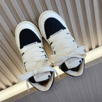 Amiri low-top sneakers with white upper and black panels, lace-up design