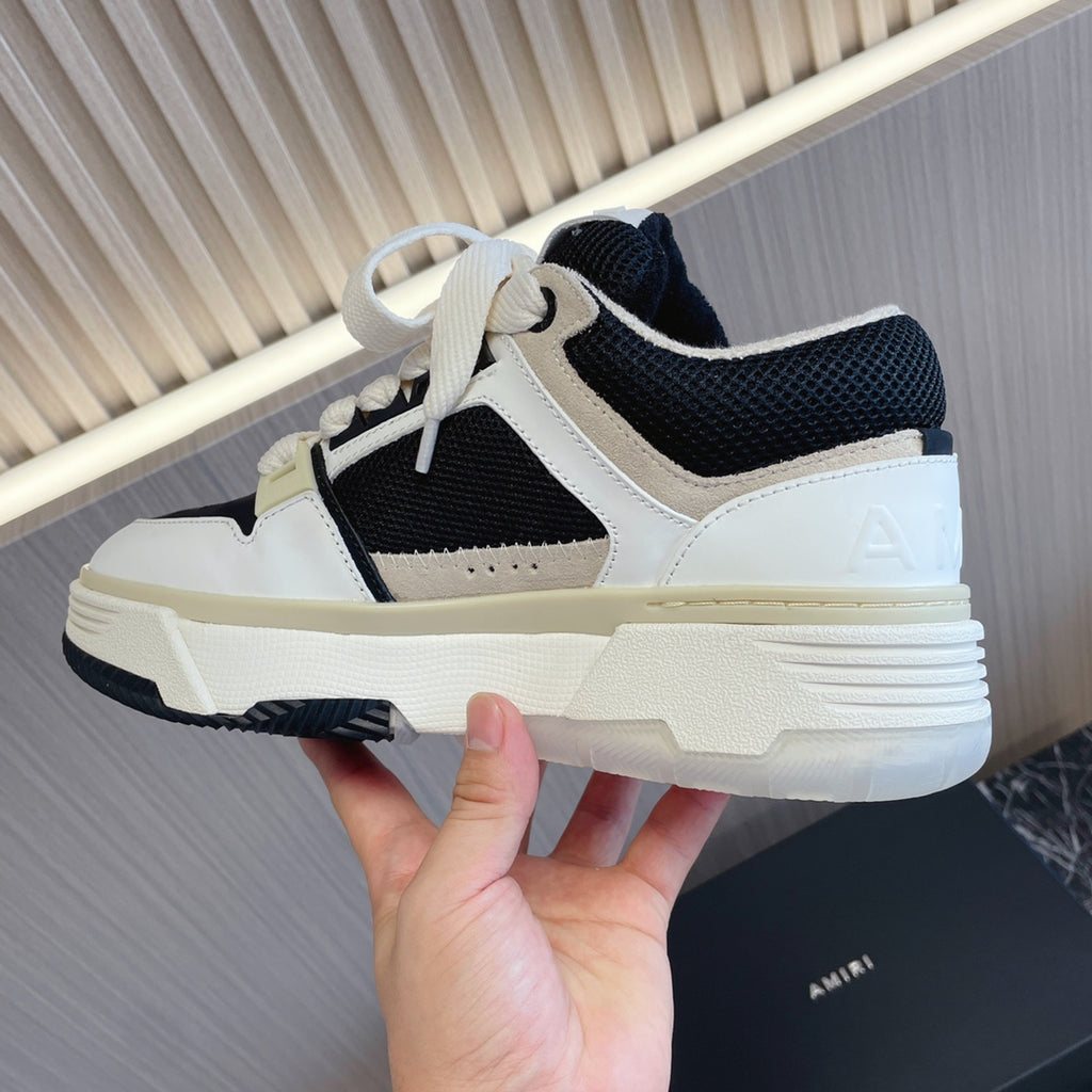 Amiri low-top sneakers with white upper, black mesh panels, light sole, lace-up
