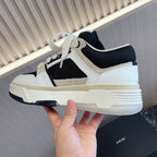 Amiri low-top sneakers with white upper, black mesh panels, light sole, lace-up
