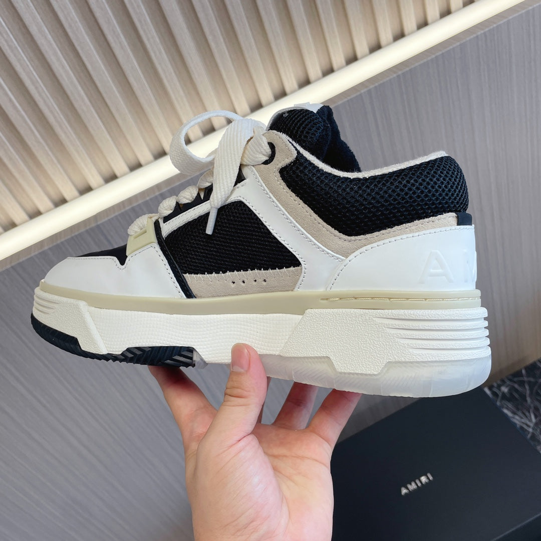Amiri low-top sneakers with white upper, black mesh panels, light sole, lace-up